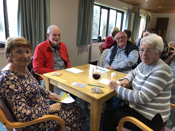 Cathy, Ken, Howard and Sandra at their table, looking at the camera and smiling.
