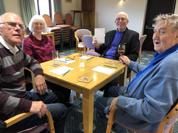 Alan H, Karen, Alan B and Kevin at their table, looking at the camera and smiling.