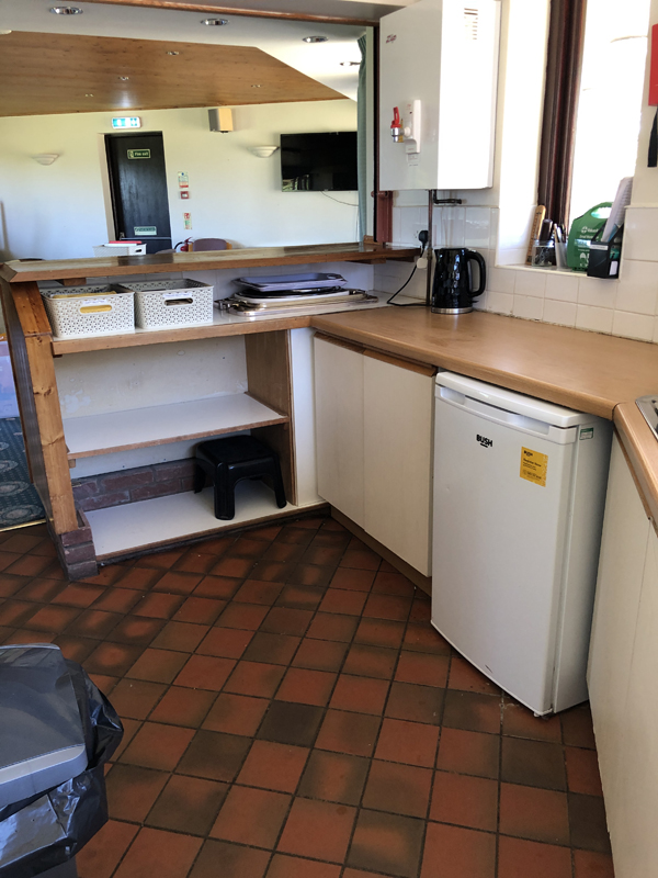 Picture of the kitchen showing cleared shelves and countertops. Taken from the oven end.