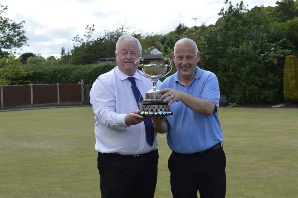 County Secretary Jim McGurk on the left. Tommy Johnstone on the right. They are holding up the Senior Merit trophy.