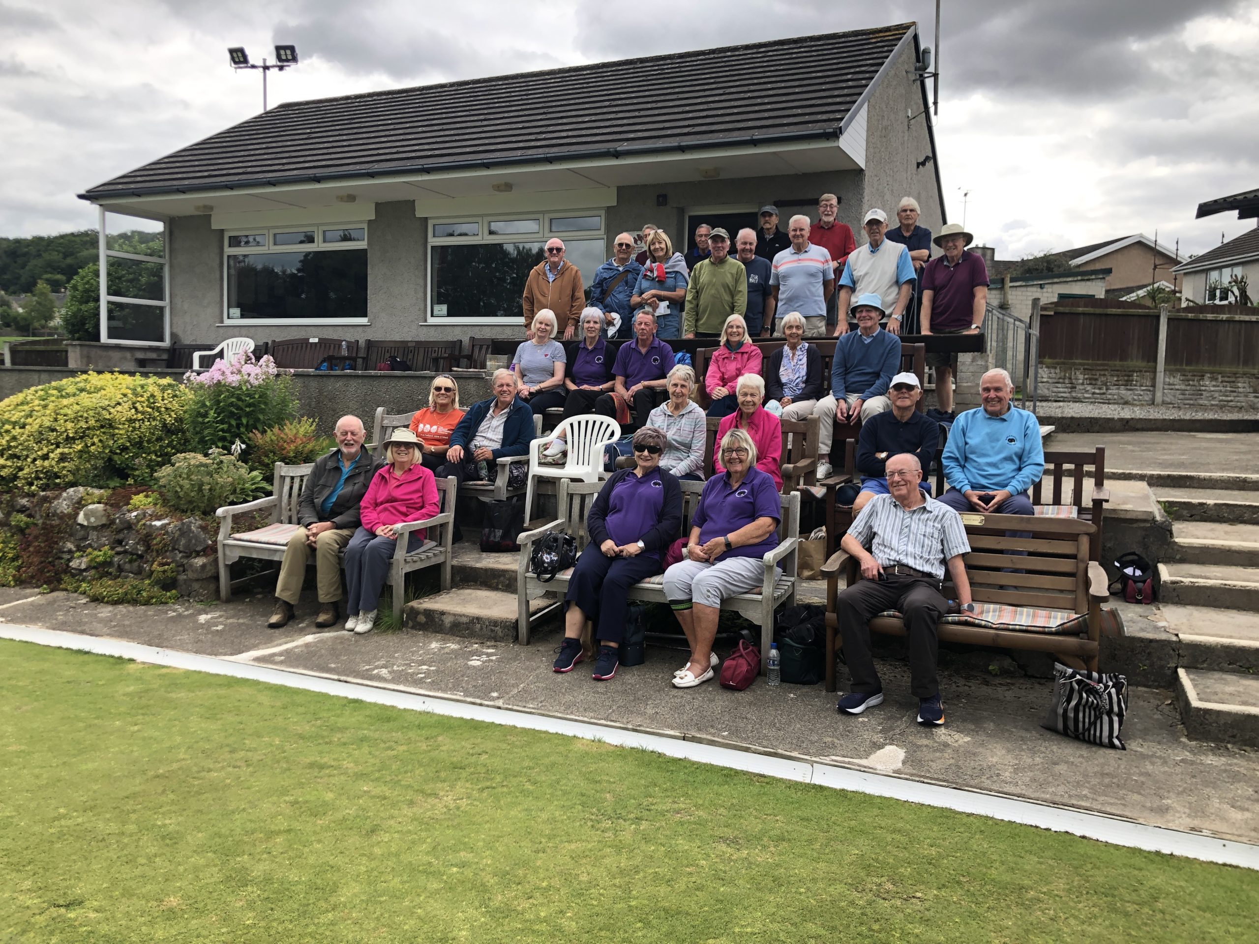 A group shot of all the bowlers who took part in the Friendly between B&P and Arnside, sitting in rows and standing at the back.