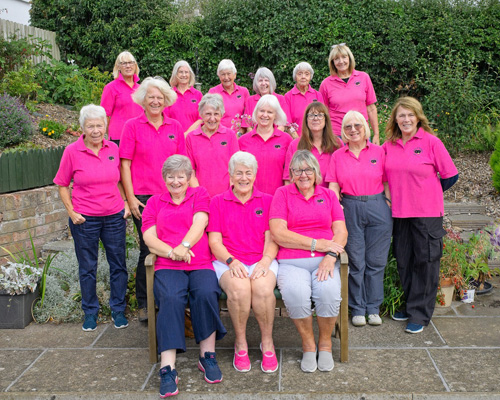 Members of the B&P Ladies League team. 16 ladies posing next to the green. Three on a bench in front, and the rest in two rows behind.