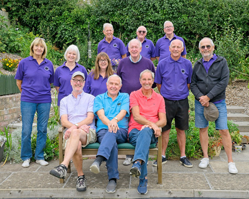 Members of the B&P Vets team (Division 3) at the green - three men sitting on a bench with three women and three men standing behind them. Three men in the back row.