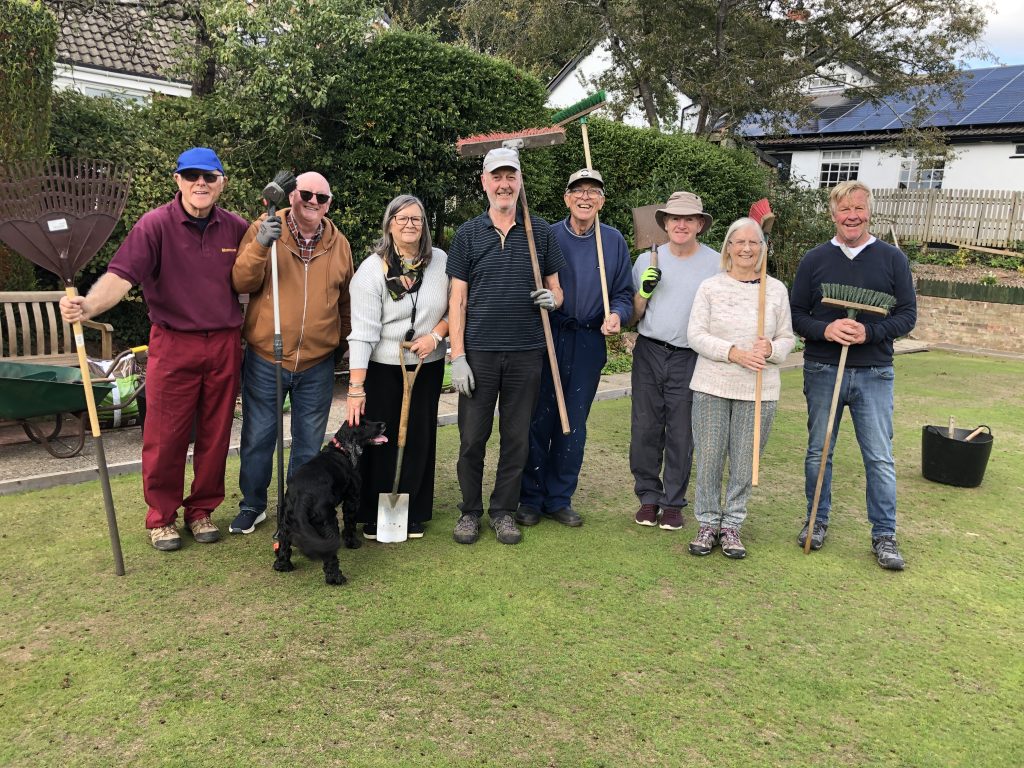 The helpers: Alan H, Howard B, Pat (with Molly the dog), Steven, Alan B, Charlie, Liz and Howard P. On the green with tools!