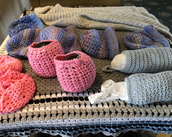 A table with a display of crocheted/knitted items.