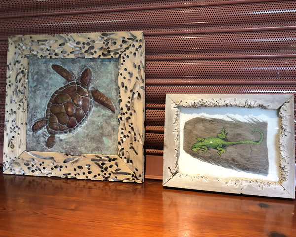 Two pictures: a copper turtle and a green lizard in driftwood frames.