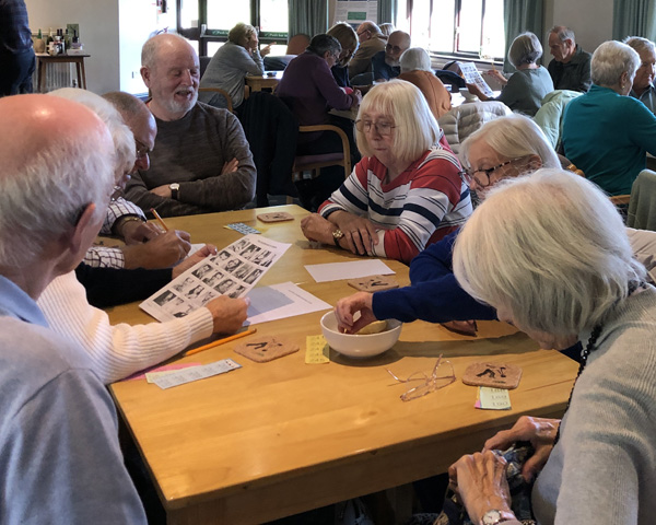 People sitting at tables in the Clubhouse intent on working out answers to the Quiz.