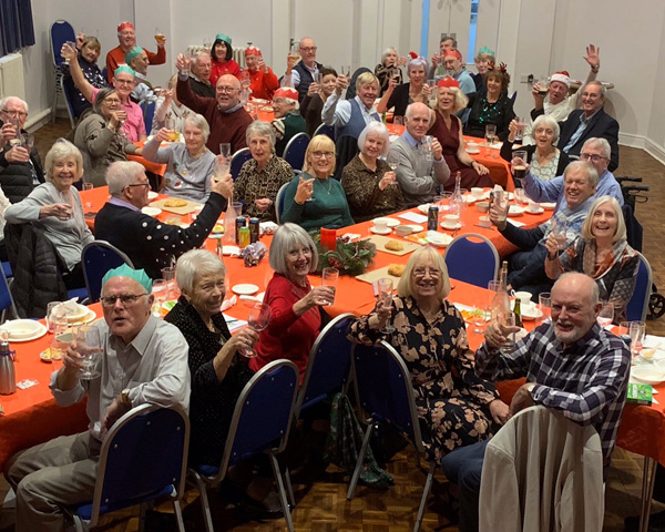 People at tables raising their glasses.