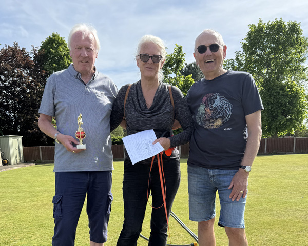 Two men, a woman standing between them. The man on the left is holding the small trophy.