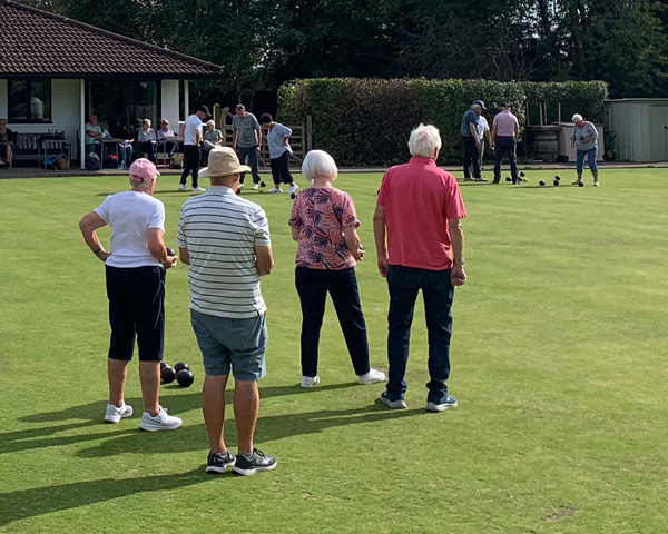 Three sets of bowlers on the green
